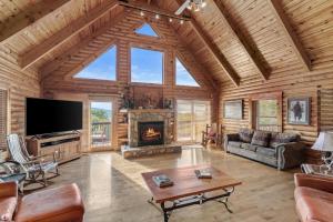 a living room with a fireplace in a log cabin at Sugar Bear Lodge in Banner Elk