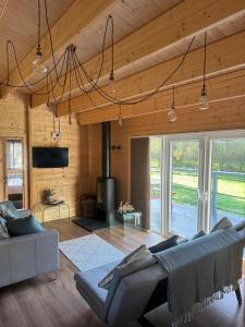 Una sala de estar con un sofá y una chimenea. en Lake Lodge at Farthings Farm, en Clyst Saint Lawrence