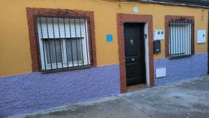 un edificio colorido con una puerta y ventanas negras en CASA LOS BLOQUES, en Zamora