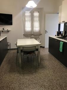 a kitchen with a white table and a table and chairs at Via Clitunno 24 in Foligno +5 photos