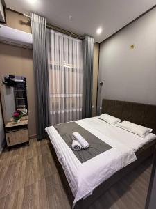 a bedroom with a large bed with two towels on it at Nari 2 Hotel in Toshkent-Passajir Bekati