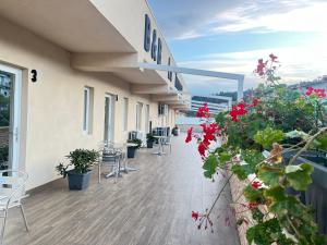 ein Balkon eines Gebäudes mit Tischen, Stühlen und Blumen in der Unterkunft La Terrazza in Cotronei