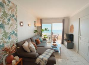 a living room with a couch and a television at T3 Vue mer à couper le souffle in Canet-en-Roussillon