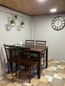 a dining room table with chairs and a clock on the wall at The mountain deer view lodge & Hershey in Ban Mung