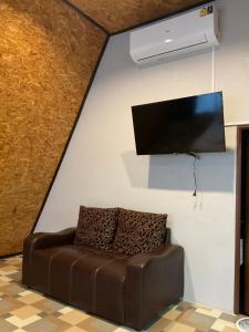 a living room with a couch and a tv on a wall at The mountain deer view lodge & Hershey in Ban Mung