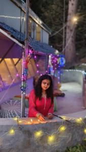 a young girl sitting on the ground with lights at The shire kalga in Kasol