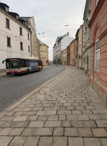 a bus is driving down a city street at Útulný apartmán v srdci Jihlavy in Jihlava