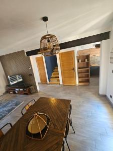 a living room with a wooden table and a chandelier at La perle rare in Le Barcarès +7 photos