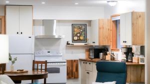 Una cocina con electrodomésticos blancos y una mesa con una silla azul. en Lay Back Lodge, en Kimberley