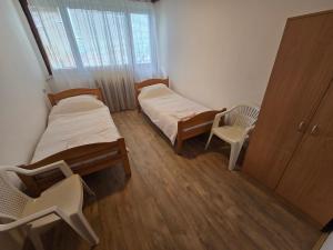 Una pequeña habitación con dos camas y una ventana. en Sobe Rogatica, en Rogatica