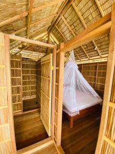 a small room with a bed in a bamboo house at Batanta Guest House in Pulau Birie