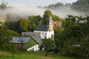 a white building with a tower and a castle at ÜbermTal in Schmallenberg