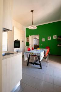 a kitchen with a table and a green wall at san Lorenzo by the sea in Augusta