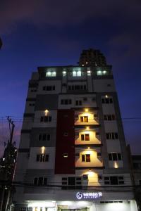 a tall building with lights on top at night at The Studio 18 Residences in Manila