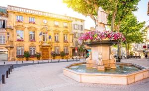 une fontaine fleurie devant un bâtiment dans l'établissement Auberge Nostradamus, Appartement 4, à Salon-de-Provence