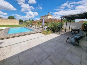 a patio with a pool and chairs and an umbrella at Le Cocon de Pinerato in Albi