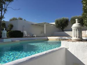 a swimming pool in front of a house at Alentejo Living in Messejana