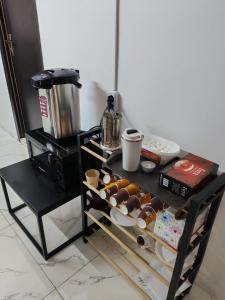 a table with a tray of donuts and a coffee maker at hotel floreale in Rustavi