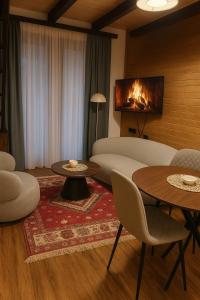 a living room with a couch and tables and a fireplace at Sun Village Apartments Zabljak in Žabljak