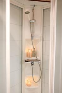 a shower in a bathroom with candles in it at Calm City Studio By BookLapland in Rovaniemi