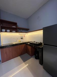 una cocina con estufa y refrigerador en Villa 160 Prambanan, en Randugunting