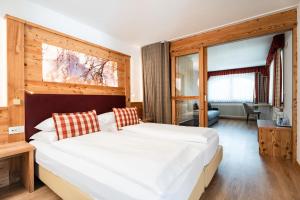 a bedroom with a large white bed in a room at Astor Suites B&B in Selva di Val Gardena +28 photos