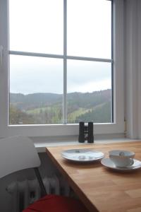 a wooden table with two plates on it with a window at ÜbermTal in Schmallenberg +35 photos