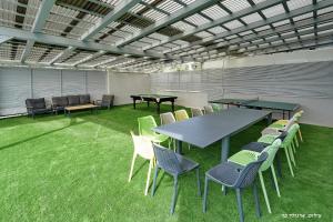 un groupe de tables et de chaises dans une pièce avec de l'herbe dans l'établissement וילות היוקרה עידן הנוף ואחוזת אסתובן, à Ya‘ara 70 autres photos