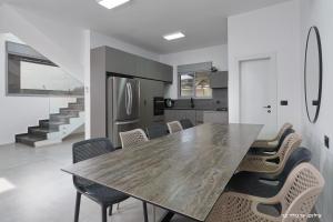 une cuisine et une salle à manger avec une table et des chaises dans l'établissement וילות היוקרה עידן הנוף ואחוזת אסתובן, à Ya‘ara