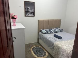 a small bedroom with a bed and a vase of flowers at Apartamento Mobiliado Dez min do Aeroporto Aeroconforto in Manaus