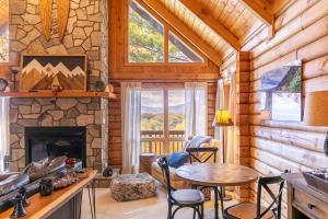 sala de estar con chimenea de piedra y mesa en Angels Envy, en Blowing Rock