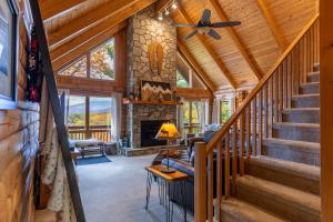 sala de estar con escaleras y chimenea de piedra en Angels Envy, en Blowing Rock