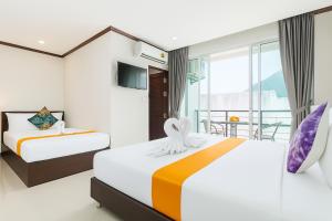 a hotel room with two beds and a balcony at The Chic Patong Hotel in Patong Beach
