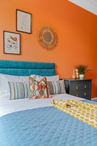 ガラシールズにあるStylish 4 Bed-Town Centreのベッドルーム1室(オレンジ色の壁の青いベッド1台付)
