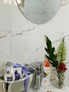 a bathroom counter with a sink with a mirror at The Manor by Orchids in Arusha