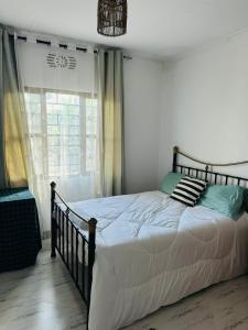 a bed in a bedroom with a large window at The Manor by Orchids in Arusha +17 photos