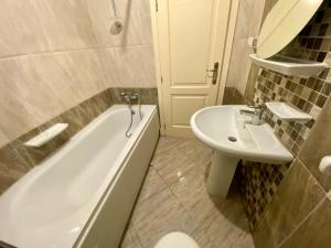 un baño con bañera y lavabo en Warm Home for You Free Wifi, en Madinaty 2 fotos más