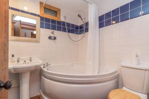 une salle de bain avec une baignoire, des toilettes et un lavabo dans l'établissement Capel-Bach, à Llanystumdwy 19 autres photos