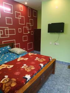 ein Schlafzimmer mit einem Bett und einem Flachbildfernseher in der Unterkunft Blueocean Residency in Virāmpattinam