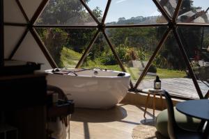 a bath tub in a room with a large window at Skydomo in Salesópolis +38 photos