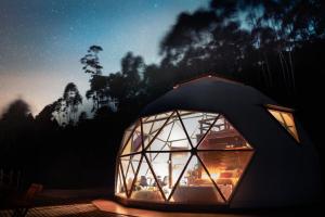 a dome greenhouse is lit up at night at Skydomo in Salesópolis