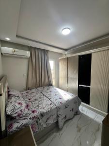 a bedroom with a bed and a window at First 6th October Compound of Degla Gardens Comfort in ‘Ezbet `Abd el-Ḥamîd