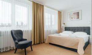 a bedroom with a bed and a chair at Jedno 17 aparts in Wrocław