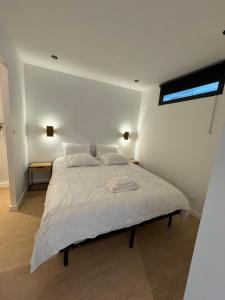 a bedroom with a bed with white sheets and a window at Appartement moderne et confortable in Fontainebleau