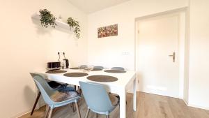 a white kitchen with a white table and chairs at Helle gemütliche 3-Zi-Whg mit Terrasse und Gartenzugang in Kulmbach