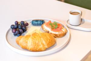 a plate of food with a croissant and a cup of coffee at RELAXANS Hotel in Dinkelsbühl