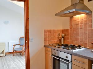 una cocina con estufa horno superior al lado de un fregadero en Taw, en Great Torrington