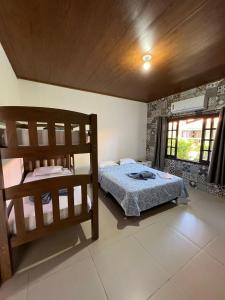 a bedroom with two bunk beds and a window at Pousada Armação das Baleias in Penha