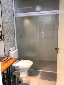 a bathroom with a toilet and a glass shower at Pousada Armação das Baleias in Penha