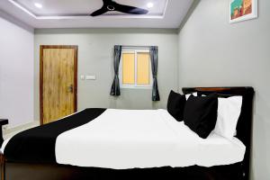 a bedroom with a white bed and a window at Hotel O Savoy Grand in Warangal